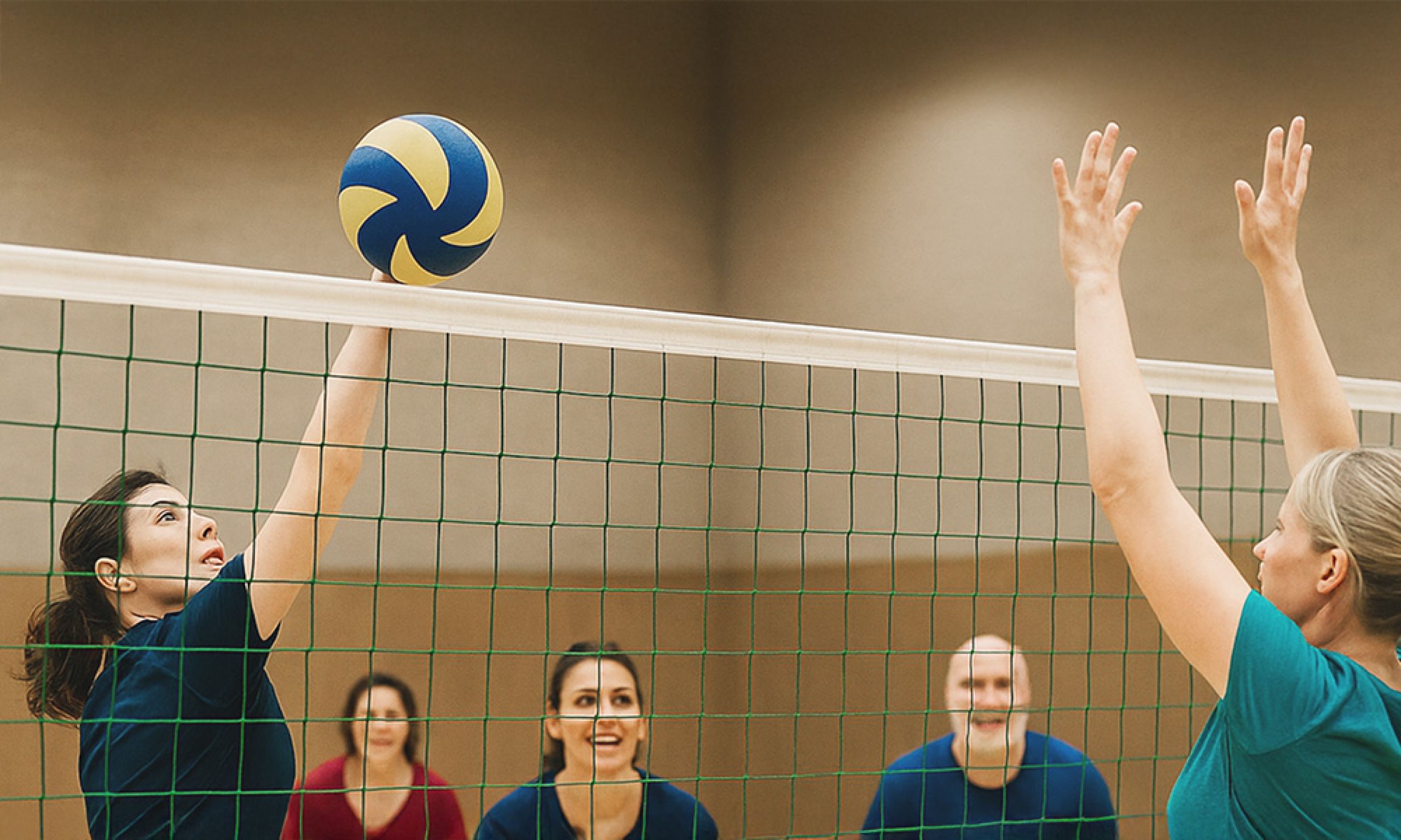 Team während eines Volleyballspiels in der Turnhalle